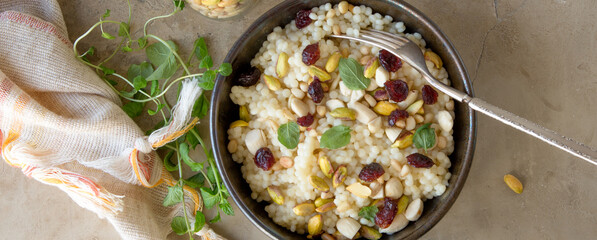 bowl of couscous with nuts and mint on the table