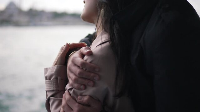 man hugging a girl in a raincoat close-up