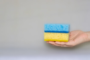 two sponges for cleaning. yellow, blue colors. space for text.
Kitchen cleaning set sponge background. sponge in woman's hand. space for text. 