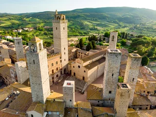 Fotobehang Toscane Luchtfoto van de beroemde middeleeuwse heuvelstad San Gimignano met zijn skyline van middeleeuwse torens, waaronder de stenen Torre Grossa. UNESCO werelderfgoed.