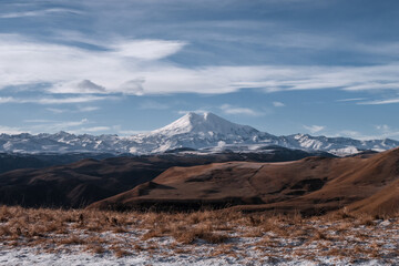 Great nature mountain range. Amazing perspective of  Elbrus with autumn fields, blue sky background.