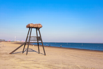 Umbrella from the sun with a roof of palm leaves on a background of the sea on a sunny day.