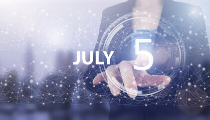 July 5th. Day 5 of month, Calendar date. Hand click luminous hologram calendar date on light blue town background. Summer month, day of the year concept.