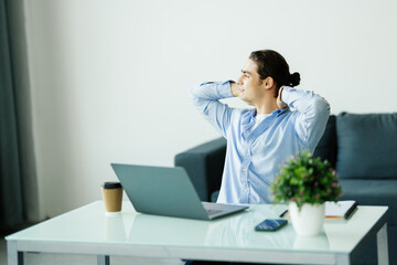Young man worker having break and resting after solving task