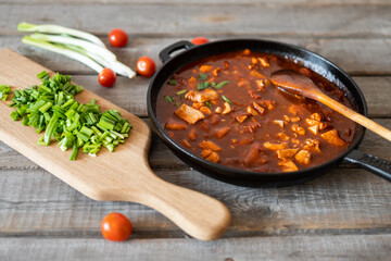 Red fish in tomato and dark beer sauce. Serving option. View from eye level.
