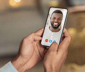 Black man holding cellphone in hand video calling distance friend
