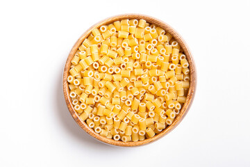  Uncooked pasta in wooden bowl on white background.