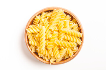  Uncooked pasta in wooden bowl on white background.