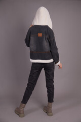 A young girl model posing at the camera demonstrates clothes in different positions.Shooting in a...