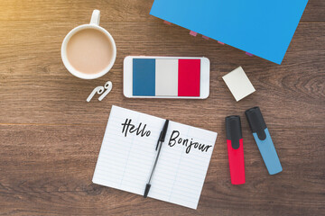 learning french online, desktop with smartphone with france flag and inscription hello on french