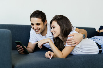 Boyfriend and girlfriend talking while looking at phone.