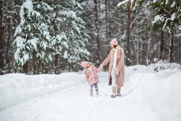 mom and daughter play in the winter forest