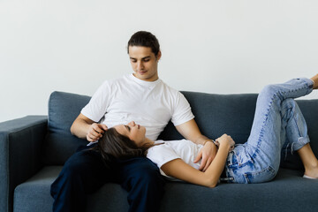 Young couple relaxing on sofa with laptop. Love, happiness, people and fun concept.