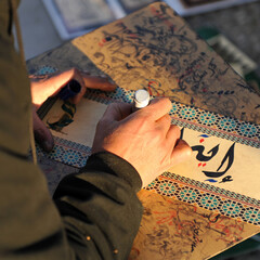Arabic calligraphy manuscript. Writer writing by hand in the street