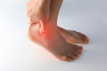 A person holding ankle on Achilles tendon, suffering with pain in red spot area. Sprain ligament or...