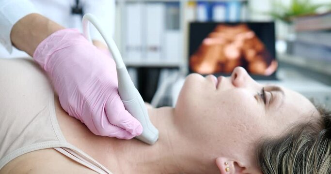Ultrasound machine doctor conducts examination of thyroid gland in woman