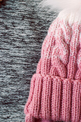 Pink knitted hat on a gray background