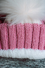 Fototapeta na wymiar Pink knitted hat on a gray background