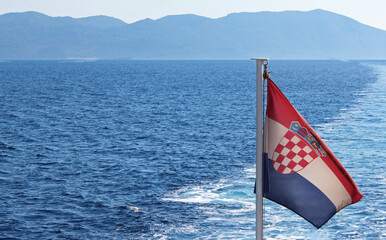 Die kroatische Flagge weht über der blauen Adria im Mittelmeer in Dalmatien im Urlaub im Sommer