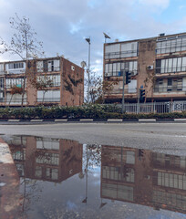 Reflection of buildings in a puddle, an old neighborhood