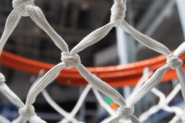 basketball hoop with a new net suspended above in a sports hall - 484629605