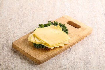 Sliced Gouda cheese over board