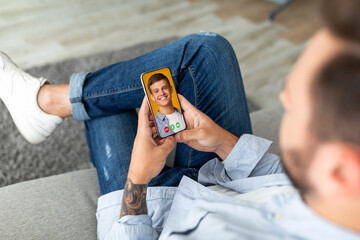 Young man holding cellphone in hand video calling distance friend