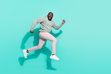 Fototapeta na wymiar Full length body size view of attractive cheerful active trendy guy jumping running isolated over vivid teal turquoise color background