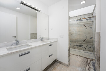 Bathroom with double sink and shower lighted with skylight