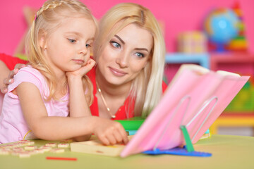 Mother and daughter playing with cubes at home