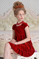 cute little  girl in red dress sitting in bedroom