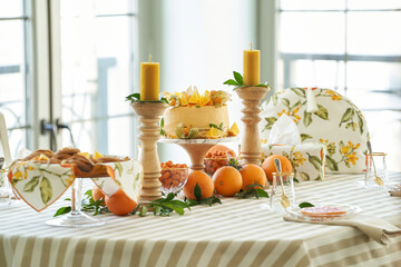 Table with orange cookies, fruits snacks.