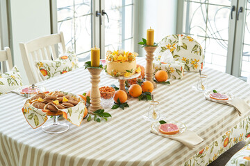 Table with orange cookies, fruits snacks.