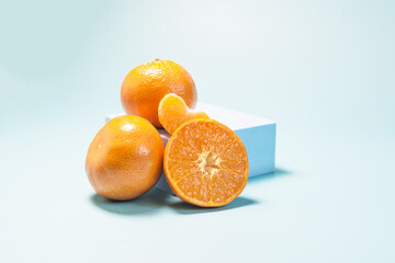Tangerines and tangerine slices on a light blue background in natural light.