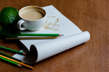 Cup of coffee latte in a cafe on a notepad on a wooden table