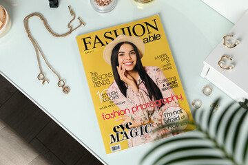 Fashion magazine and jewelry on white table indoors, flat lay