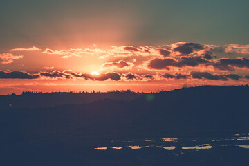 Sun sets in clouds, orange