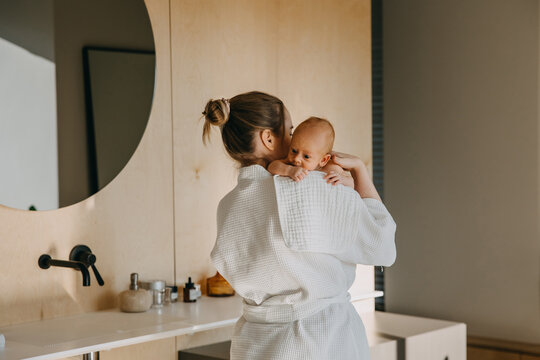 Mother Holding Newborn Baby On Shoulder, With A Burping Cloth.