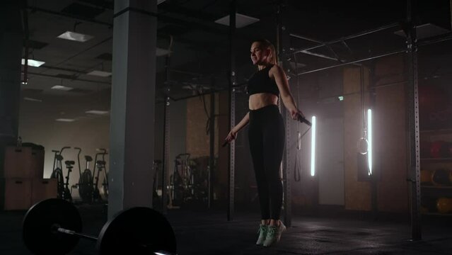 Slow motion: Young woman skipping rope. woman jump roping in the gym as part of her workout routine, determined woman focused