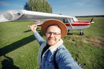 Concept training private aviation. Selfie photo happy man pilot background white aircraft cockpit - obrazy, fototapety, plakaty