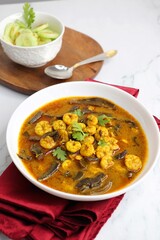 Tangy and spicy Shrimp curry. Tiny prawns curry made using dried mango and Indian spices. garnished with coriander and served with cucumber slices. Copy space.