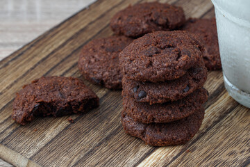 close up a stack of dark chocolate cookies on a chopping board