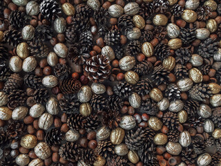 Autumn vibe background texture formed from pine cones, gold and silver walnuts and flat laid on table
