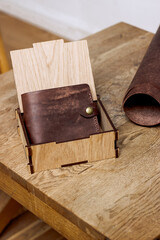 Fototapeta premium Brown genuine leather wallet on a wooden table in a box