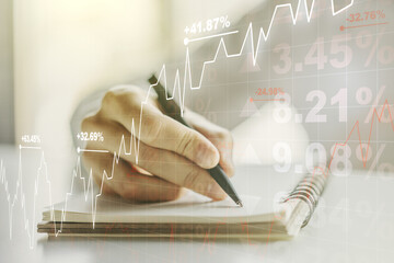 Multi exposure of abstract creative financial graph with hand writing in notepad on background, forex and investment concept