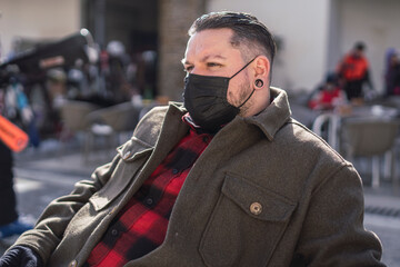 man with white hair and stretched ears weareing a black mask