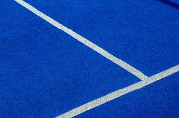 Fototapeta na wymiar Balls next to the net of a blue paddle tennis court.