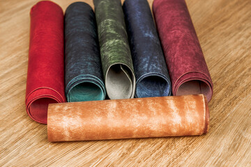 Rolls of genuine leather on a wooden table