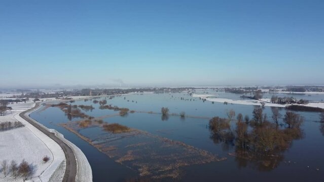 High water level on the snowy floodplains of the river IJssel near the city of Zwolle in Overijssel, The Netherlands. Aerial drone point of view.
