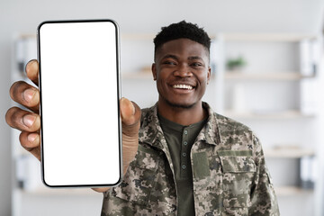 Attractive black soldier in military uniform showing his smartphone, mockup